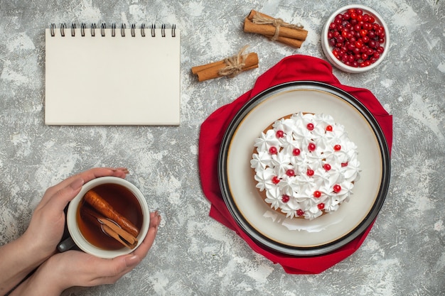 Top view of delicious creamy cake decorated with fruits on a red cloth