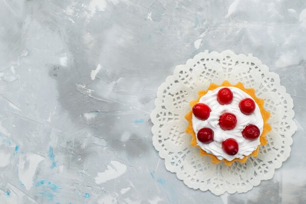 Top view delicious creamy cake with cream and red fruits on the grey surface biscuit sweet cake sugar fruit