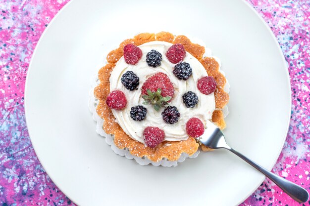 вид сверху вкусного сливочного торта с разными свежими ягодами на ярко-светлых, ягодных свежих кислых фруктах