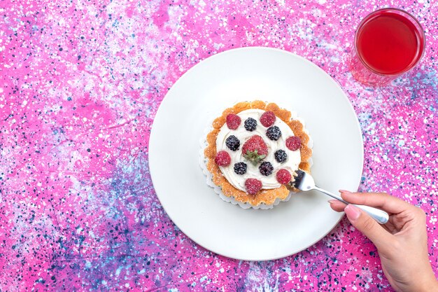 top view of delicious creamy cake with different fresh berries on top with juice on bright-light, berry fruit fresh