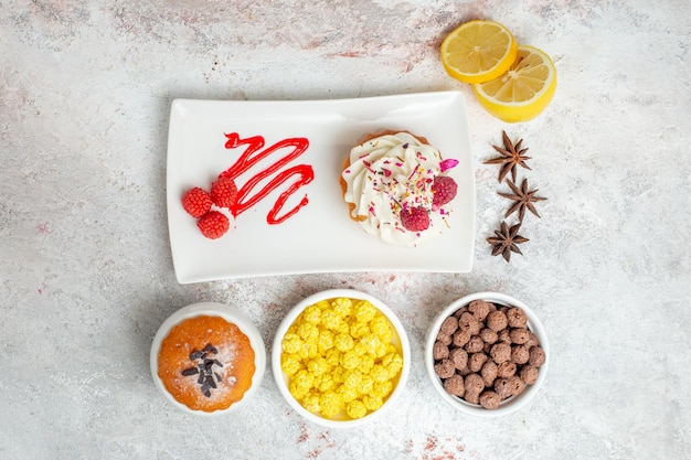Free photo top view delicious creamy cake with lemon and candies on the white background biscuit cream cake tea candy
