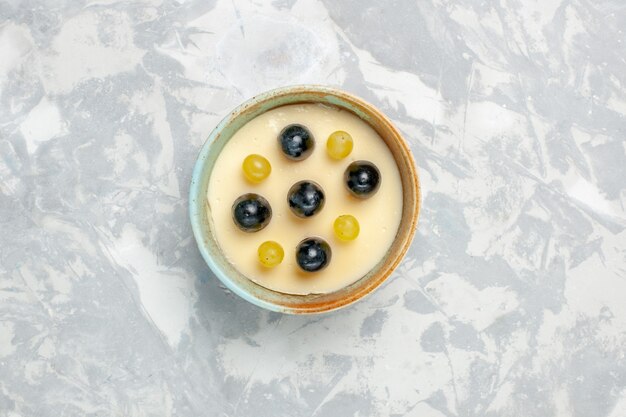 Top view delicious creamy dessert with fruits on top inside little pot on white background fruit cream dessert ice-cream sweet ice