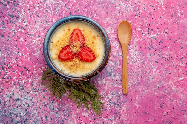 Foto gratuita vista dall'alto delizioso dessert cremoso con fragole rosse a fette all'interno della pentola su sfondo rosa dessert gelato crema dolce frutti di bosco