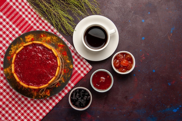 Top view delicious dessert cake with cup of coffee and fruit jams on dark background biscuit sugar cookies sweet cake dessert