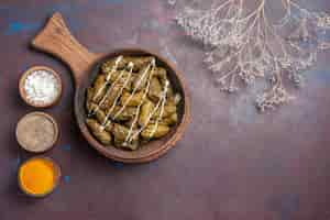 Foto gratuita vista dall'alto delizioso piatto di carne dolma con diversi condimenti su uno sfondo scuro piatto per cena cibo carne calorie