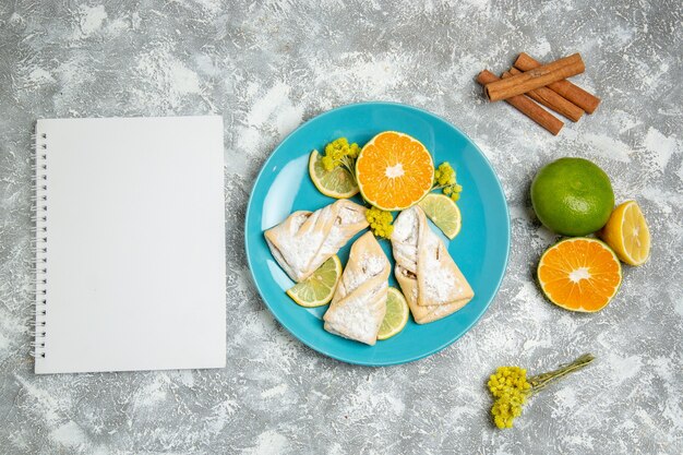 Top view delicious dough pastries with lemon slices on the white background pastry sugar bake cake dough sweet cookie