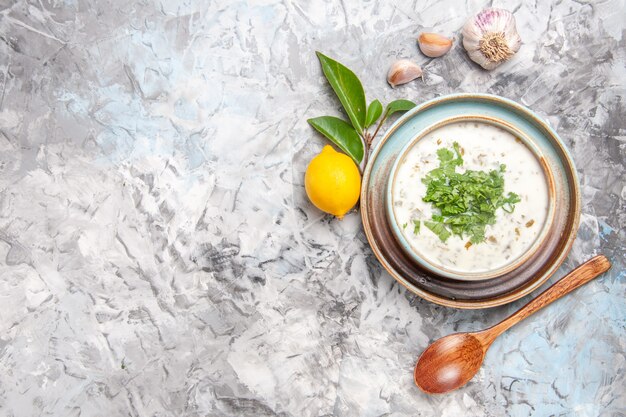 Top view delicious dovga yogurt soup with greens on white table milk soup dish dairy