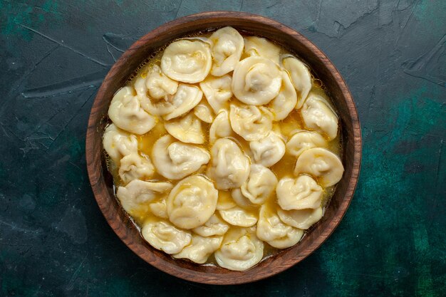 Foto gratuita vista dall'alto deliziosa zuppa di gnocchi all'interno del piatto marrone su sfondo verde scuro pasta alimentare zuppa di verdure carne