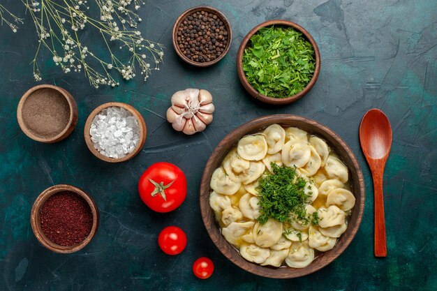 Top view delicious dumpling soup with different seasonings on a green surface soup food meat dough vegetables