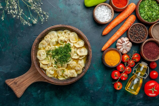 Vista dall'alto deliziosi gnocchi con verdure e condimenti diversi su carne di pasta prodotto ingrediente alimentare pasto superficie verde scuro