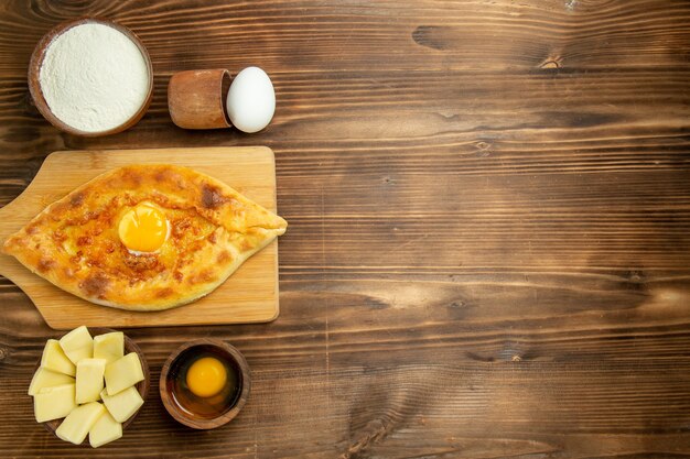 上面図茶色の木製テーブルパンパンで焼いたおいしい卵パン朝食の卵を焼く