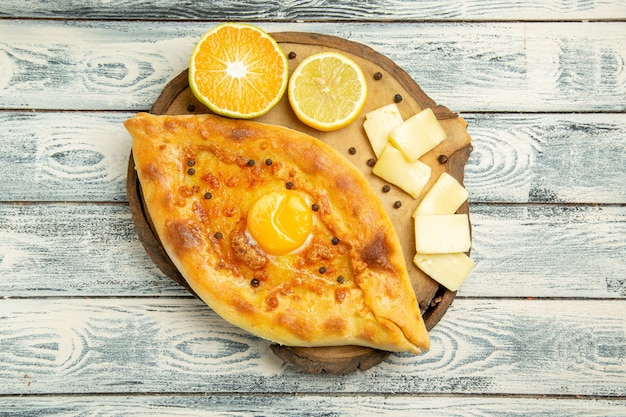 Vista dall'alto delizioso pane all'uovo cotto con formaggio sulla scrivania rustica