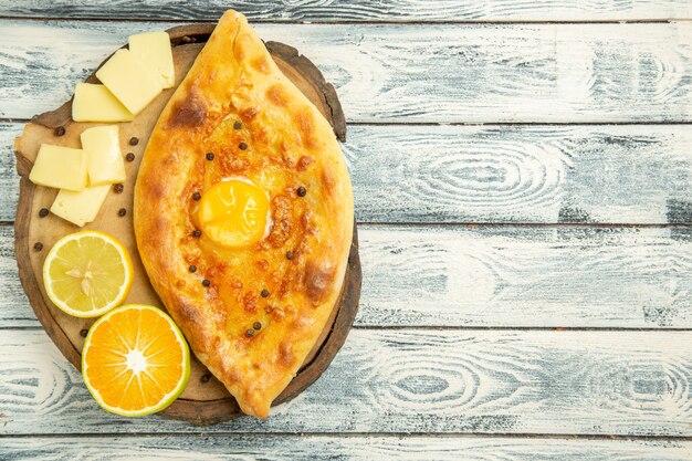 Top view delicious egg bread baked with cheese on a rustic desk