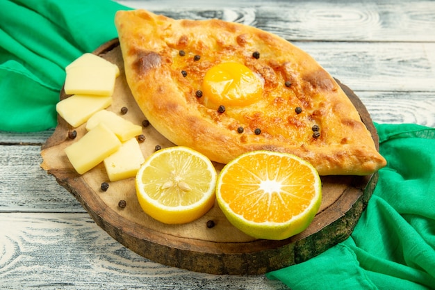 Вид сверху вкусного яичного хлеба, запеченного с сыром на деревенском сером столе