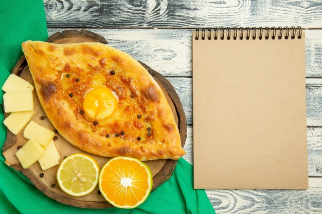 Top view delicious egg bread baked with cheese on a rustic grey desk