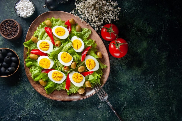 top view delicious egg salad consists of olives and green salad on dark background