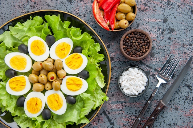 top view delicious egg salad with seasonings and olives on light background