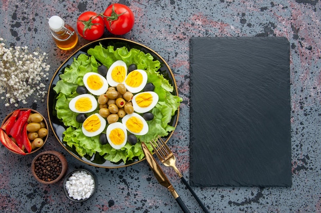 Vista dall'alto deliziosa insalata di uova con pomodori e olive su sfondo chiaro