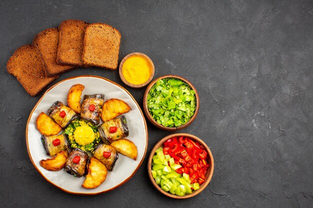 Top view delicious eggplant rolls cooked dish with baked potatoes on a dark background dish cooking food potato fry bake