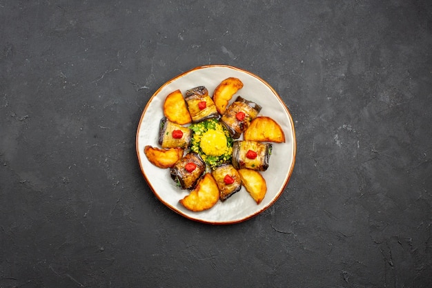 Foto gratuita vista dall'alto deliziosi involtini di melanzane piatto cucinato con patate al forno sullo sfondo scuro piatto da pasto cucinare cibo cuocere patate fritte