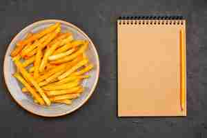 Free photo top view delicious french fries inside plate on a dark background potato meal sandwich dish burger fast-food