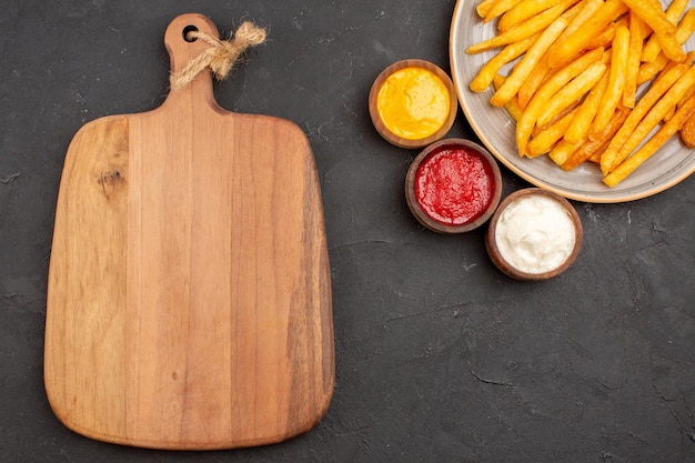 Top view delicious french fries with seasonings on dark background dish potatoes meal fast-food burger