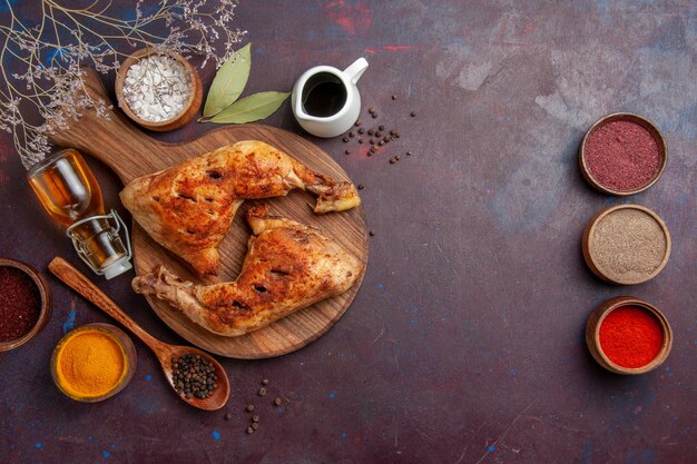 Top view delicious fried chicken with seasonings on dark space