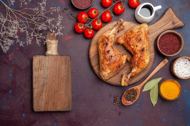 Top view delicious fried chicken with seasonings and vegetables on dark purple space