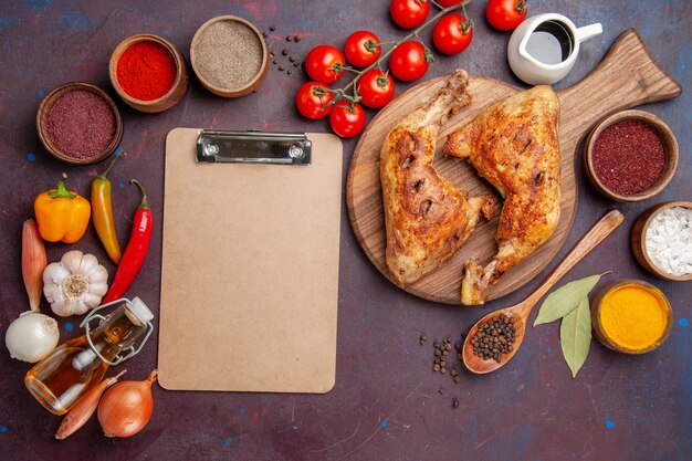 Top view delicious fried chicken with seasonings and vegetables on a dark space