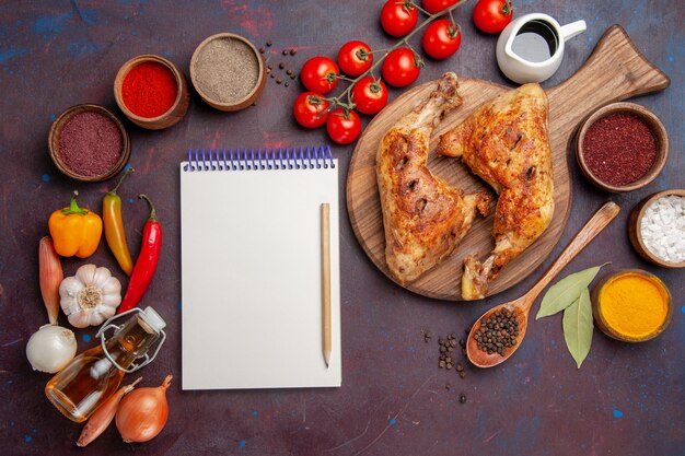 Top view delicious fried chicken with seasonings and vegetables on dark the space