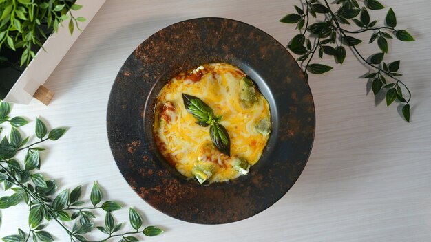 Top view of delicious frittata on a black plate on a wooden surface