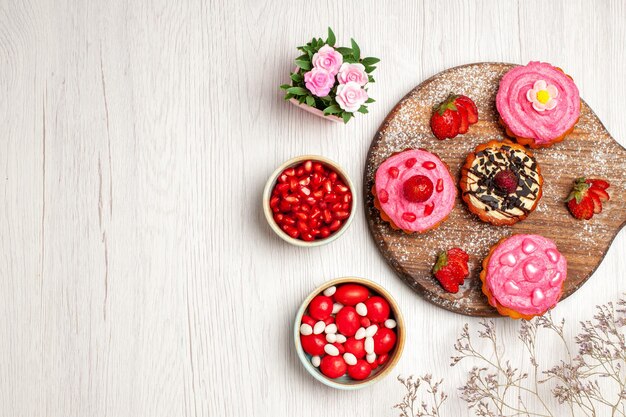 Top view delicious fruit cakes creamy desserts with candies and fruits on a white background cream sweet cookie dessert cake tea