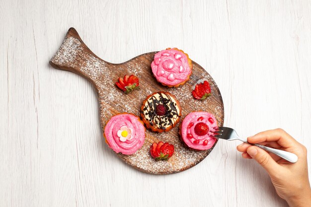 Top view delicious fruit cakes creamy desserts with fruits on light white background cream tea sweet dessert cake cookie