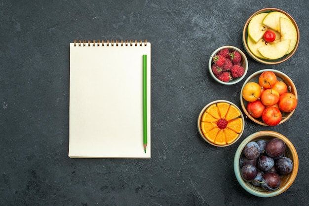 Foto gratuita vista dall'alto deliziosa composizione di frutta frutta fresca su sfondo scuro frutta fresca matura dieta salutare dolce