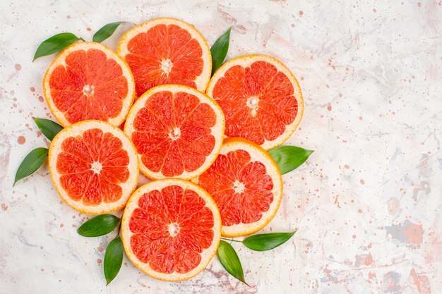 Top view delicious grapefruits slices on nude table with copy space