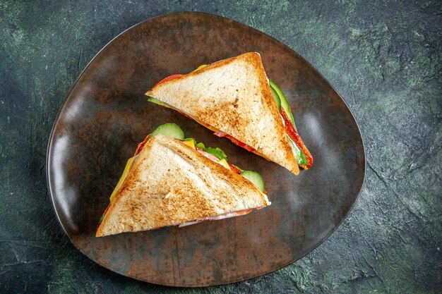 Top view delicious ham sandwiches inside plate dark surface