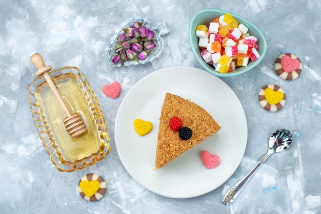 A top view delicious honey cake with candies honey on the blue background cake tea candy bake dessert