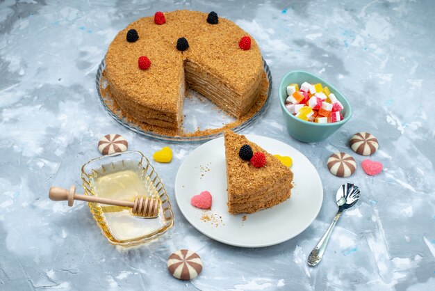 A top view delicious honey cake with candies honey on the blue background cake tea candy