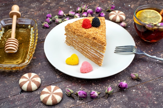 Вид сверху вкусный медовый торт с конфетами, медом и цветами на темном фоне, торт, чай, конфета, выпечка