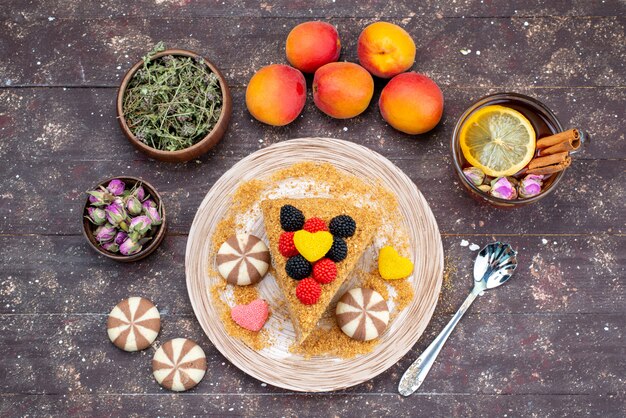 A top view delicious honey cake with candies honey and peaches on the dark background cake tea candy honey