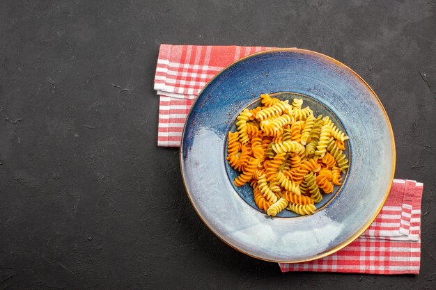 トップビューおいしいイタリアンパスタ珍しい調理済みスパイラルパスタ暗い背景パスタ料理食事料理ディナー