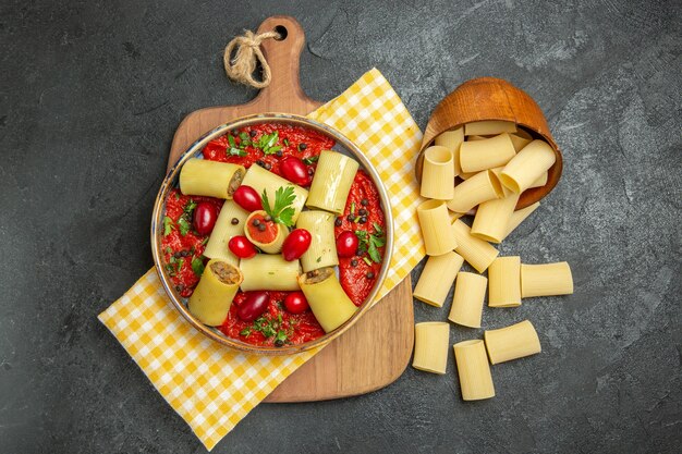 Foto gratuita vista dall'alto deliziosa pasta italiana con carne e salsa di pomodoro sull'impasto della cena cibo pasta pasto superficie grigio scuro