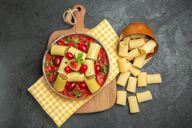 Вид сверху вкусной итальянской пасты с мясом и томатным соусом на темно-серой поверхности еда макароны еда обед тесто