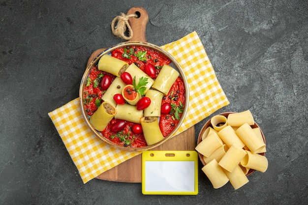 Foto gratuita vista dall'alto deliziosa pasta italiana con carne e salsa di pomodoro sul muro grigio scuro pasta pasto cena pasta alimentare