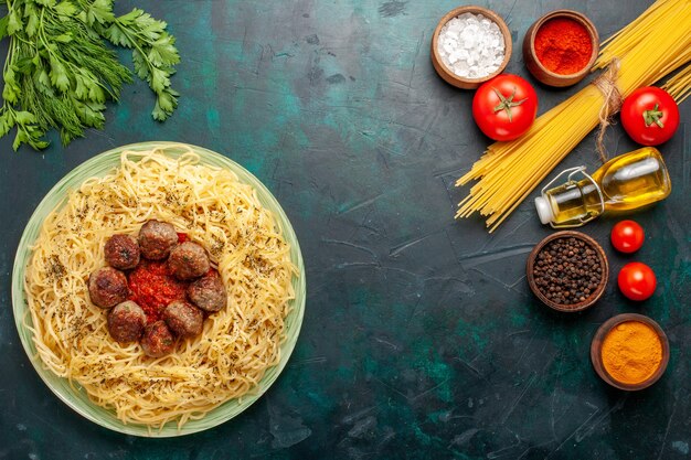 Вид сверху вкусной итальянской пасты с фрикадельками и томатным соусом на темно-синем столе тесто блюдо из пасты мясная еда италия