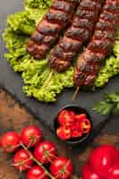 Foto gratuita vista dall'alto di un delizioso kebab su ardesia con insalata e pomodori