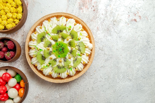 밝은 흰색 배경에 사탕과 상위 뷰 맛있는 키위 디저트 디저트 케이크 크림 과일 열대