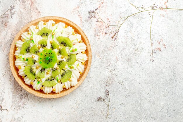 Top view delicious kiwi dessert with yummy white cream and sliced fruits on a white background dessert cake cream fruit tropical