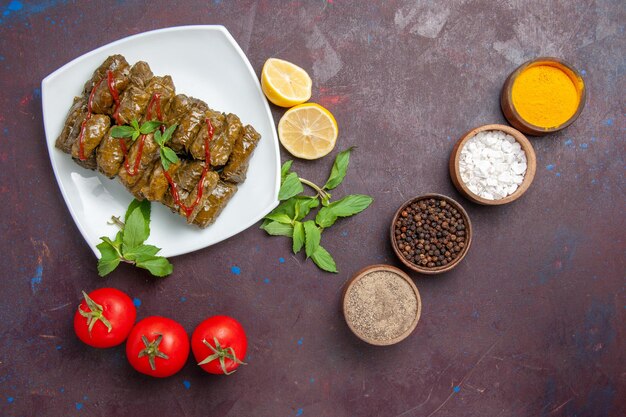 Top view delicious leaf dolma ground meat dish with lemon and tomatoes on the dark background dish leaf dinner food meat