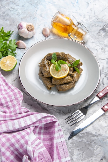 Вид сверху вкусной листовой долмы внутри тарелки на белой поверхности